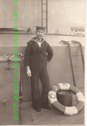 WWII Japanese Navy Sailor Standing next to a life ring on a ship Photo